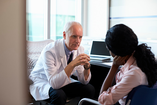 Doctor In Consultation With Female Patient