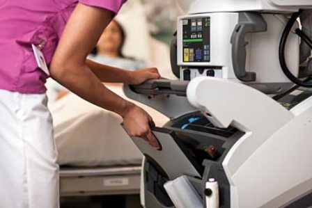 Nurse pulling detector out of the DRX-Revolution mobile x-ray system.