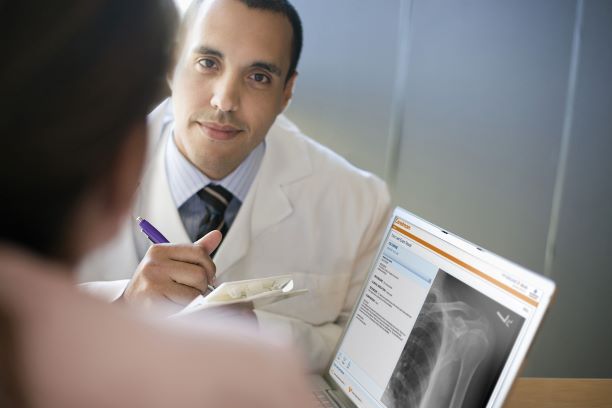 Patient and doctor looking at radiograph on a tablet