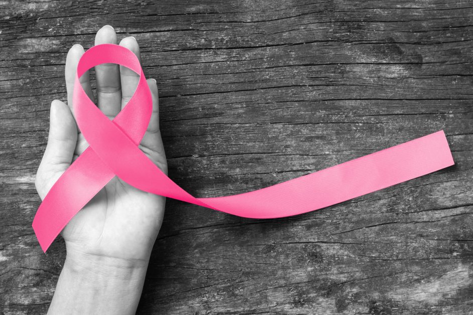 Símbolo de conciencia de cinta rosa en mano de mujer
